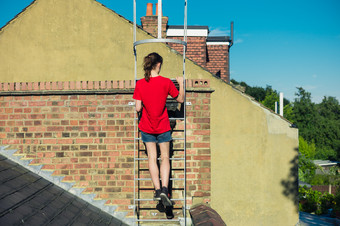 红衣女孩爬梯子上屋顶