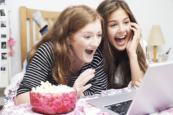 两个女孩开心大笑看电脑