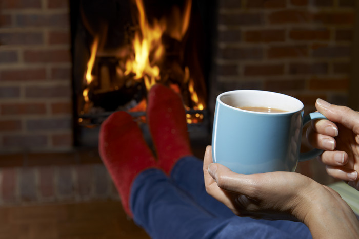 坐在壁炉旁取暖喝咖啡