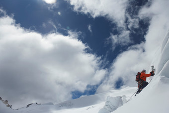 蓝天下男人攀登雪山