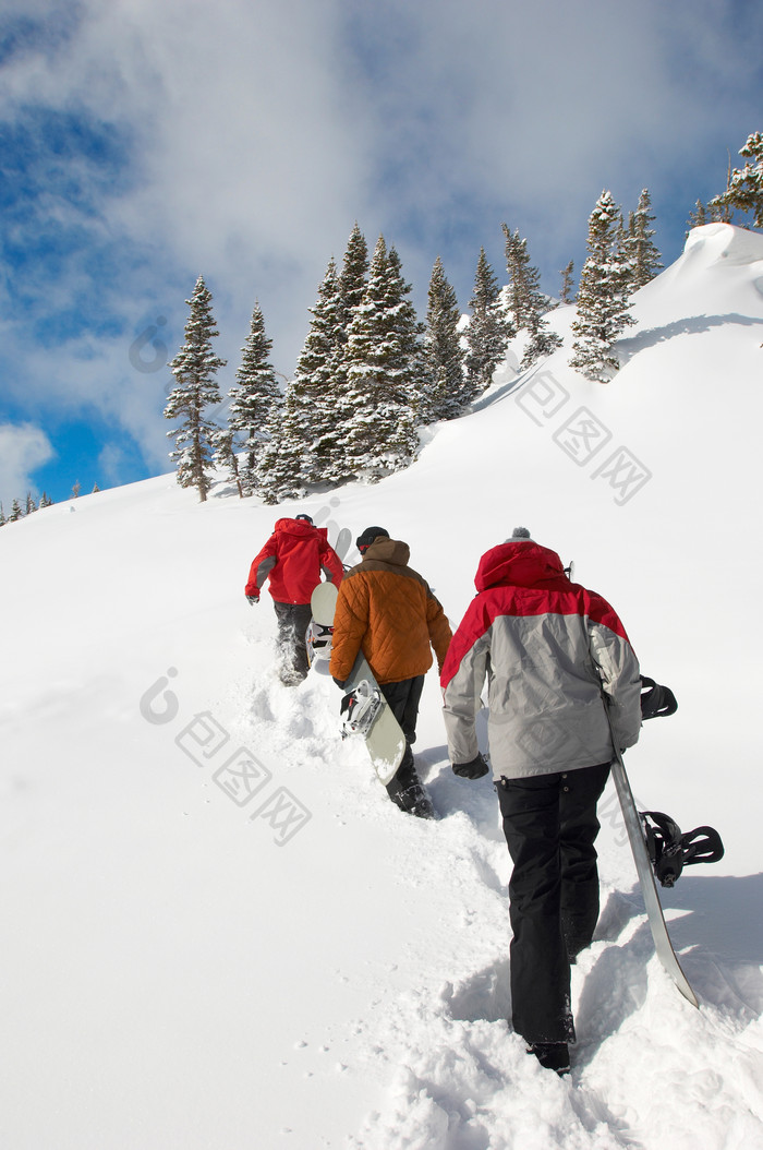 抱着滑雪板爬雪山的人