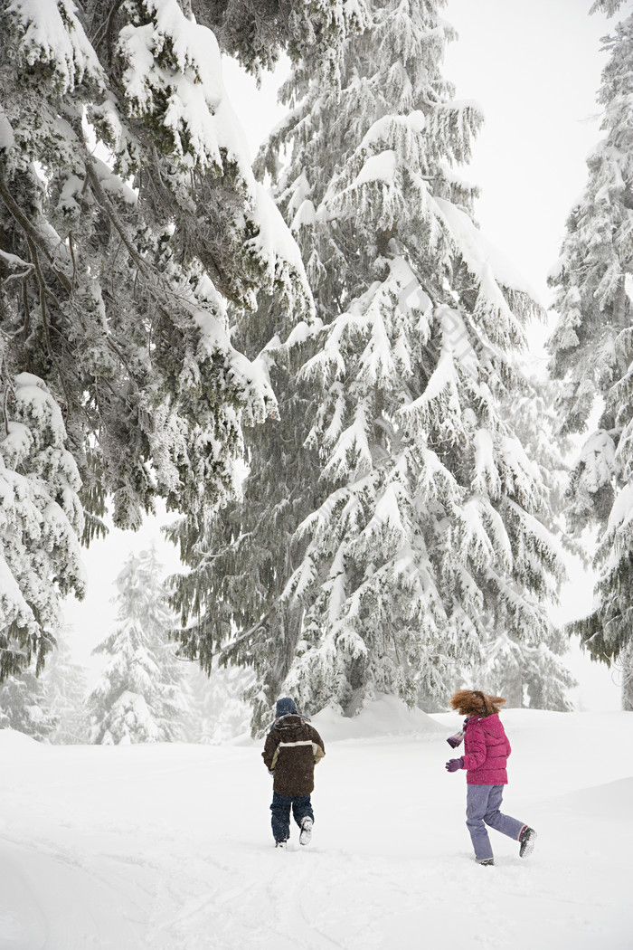 暗色调雪中玩耍的儿童摄影图
