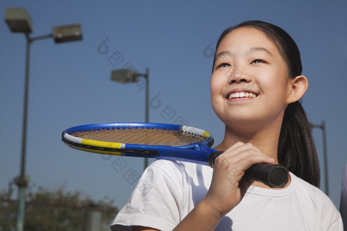 扛着网球拍的女孩摄影图