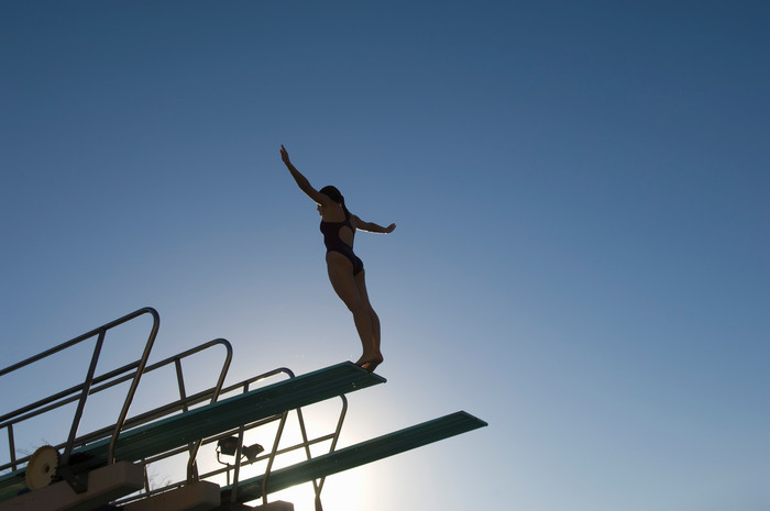 阳光中运动员跳台跳水人影