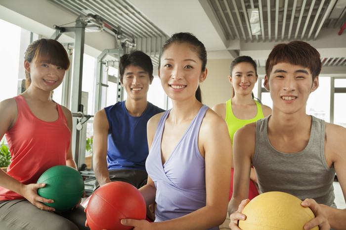 女人年轻的健身锻炼运动一群人抱着球摄影图