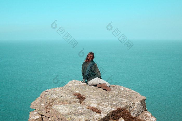 坐着岩石上看海的女孩