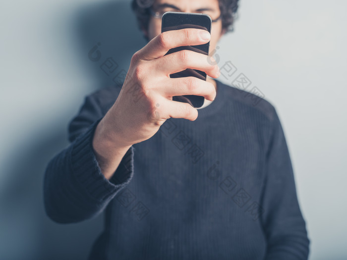 举起手机拍照的男人