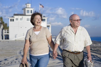 海边牵手散步的老年夫妻