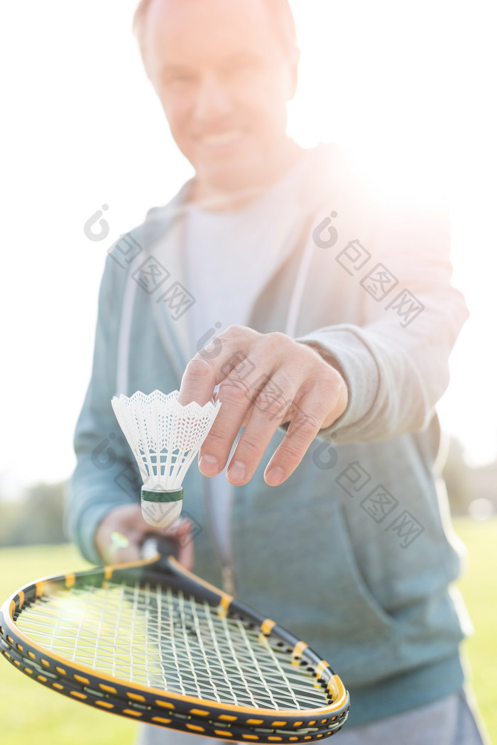 草地上打羽毛球的老年男人