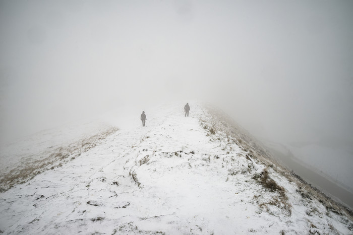 雪地中行走的人摄影图
