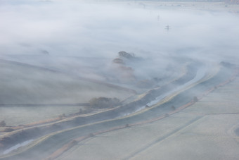 起雾的草坪小河摄影图