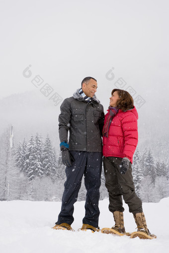 灰色调雪地上的夫妻摄影图