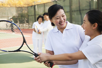 户外场地打羽毛球羽毛球拍一家人父母<strong>女儿</strong>图