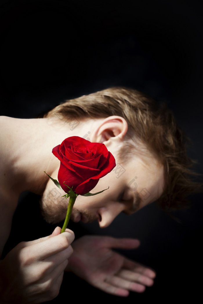 暗色调拿玫瑰的人摄影图
