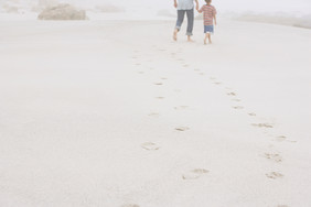 沙滩上散步的父子脚印