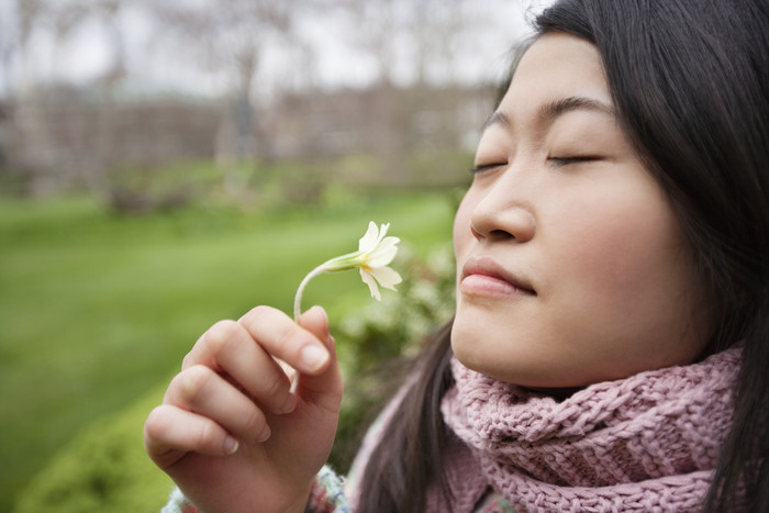 深色调闻花的女孩摄影图