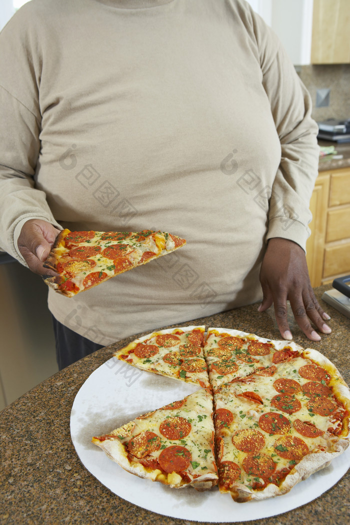 暗色调吃大比萨的人摄影图