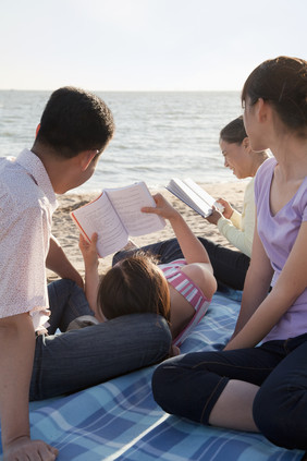 海边看书的一家人