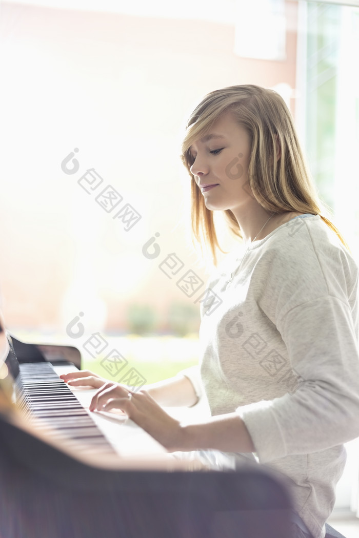 简约风弹钢琴的女孩摄影图
