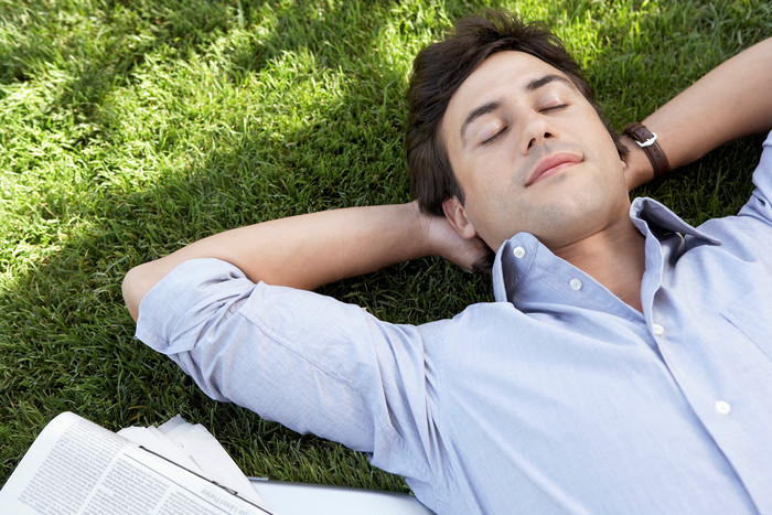 深色调在草地上躺着的男人摄影图