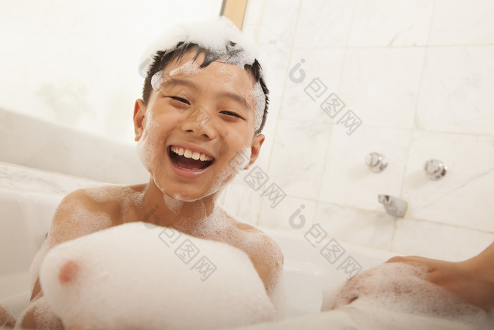 小男孩泡澡浴缸泡泡洗澡妈妈家人微笑摄影图