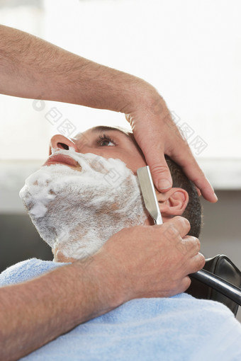 刀片刮胡子的男人