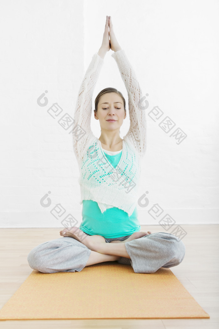 女人坐在瑜伽垫上盘腿