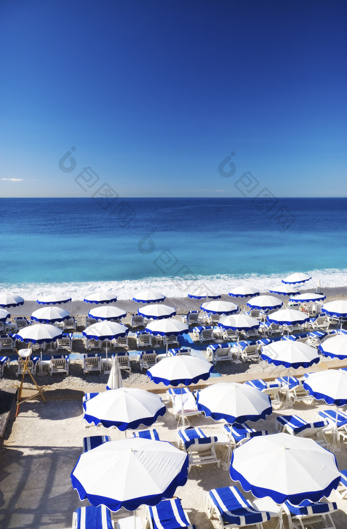 蓝色调沙滩上的遮阳伞摄影图