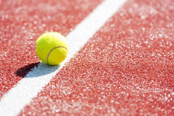 红色调场地上的网球摄影图