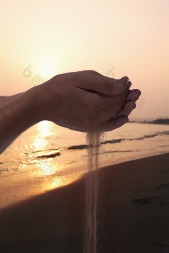 海边抓沙子的手摄影图