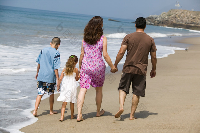 清新海边散步的夫妻和孩子摄影图