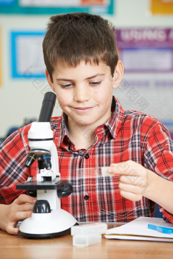 男学生在看显微镜摄影图