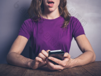 紫色调看手机的女人摄影图