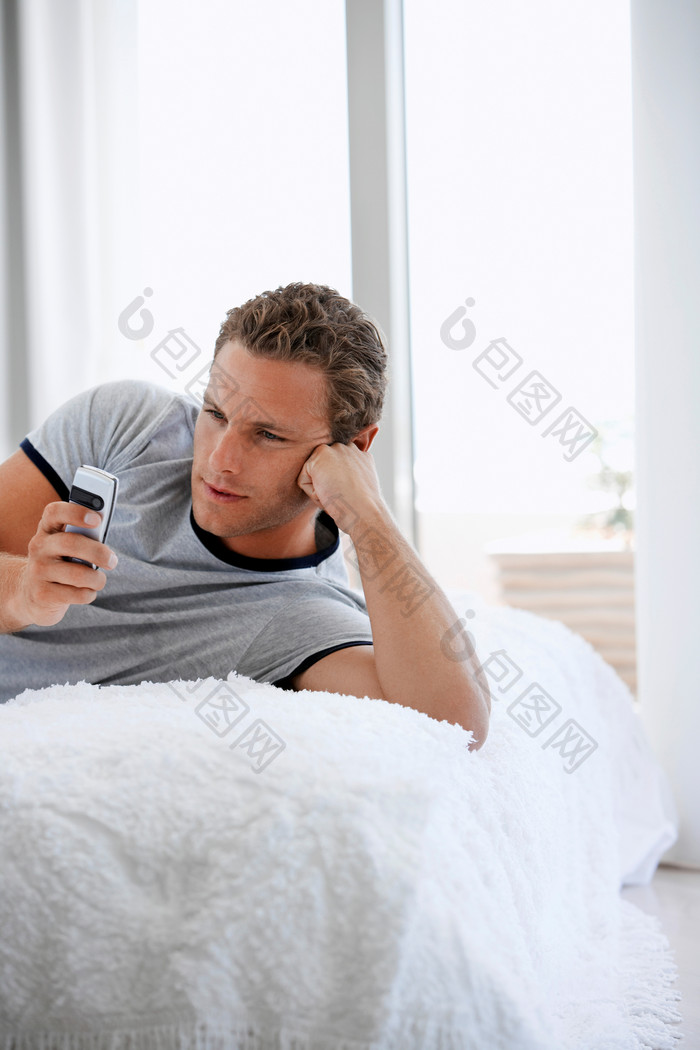 躺毛毯玩手机的男人