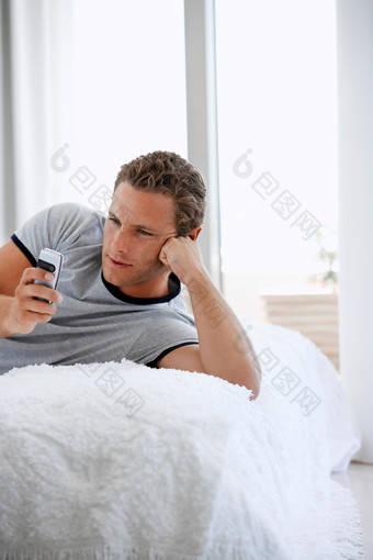 <strong>躺</strong>毛毯玩手机的男人