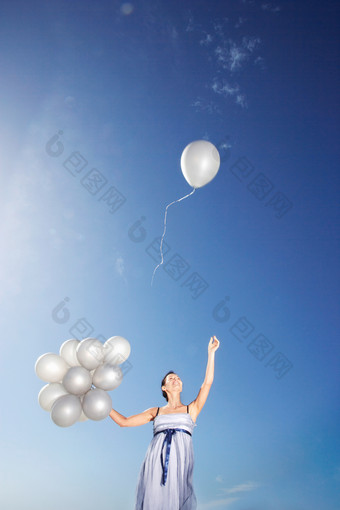 放飞气球的女人摄影图