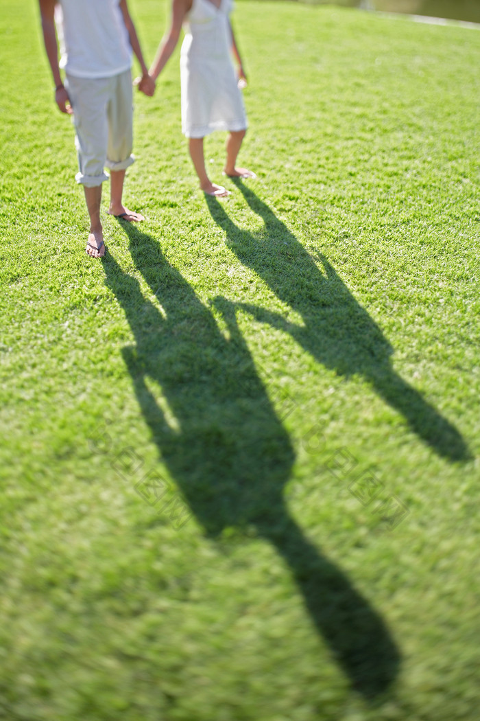 绿色调在草地上的夫妻影子摄影图