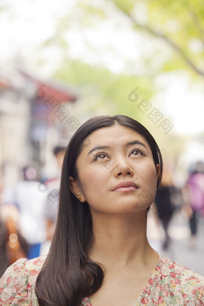 女人户外抬头长头发的美女街上逛街休闲