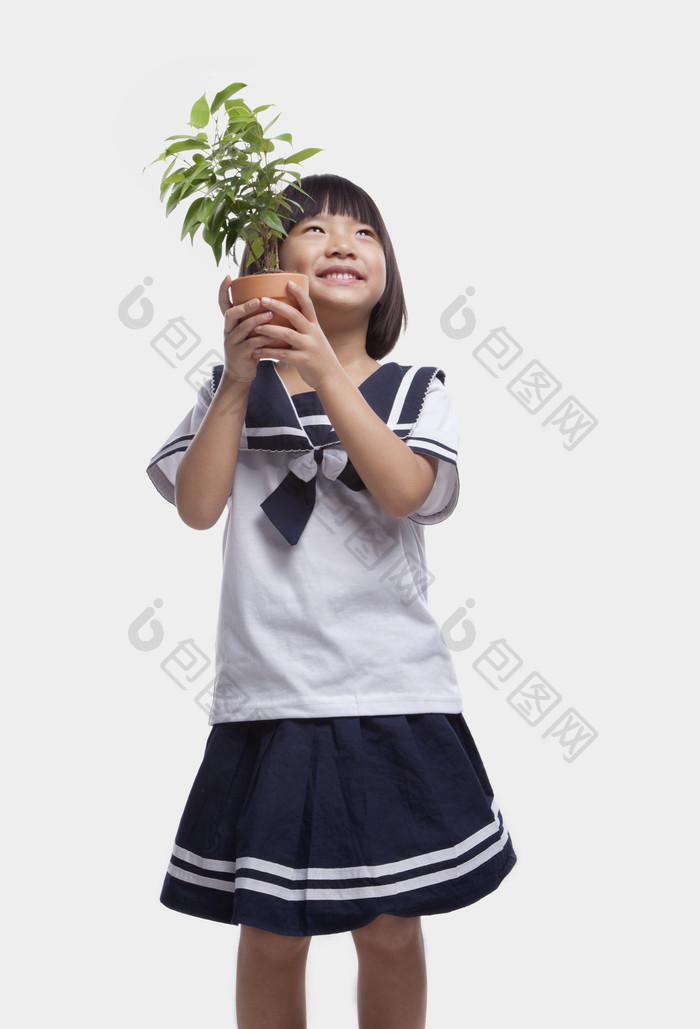 穿着制服校服的小女孩学生拿着盆栽憧憬环保