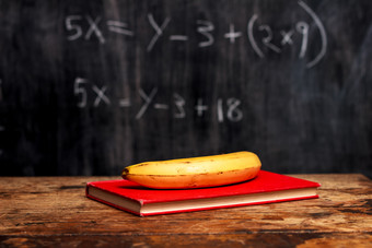 暗色调老师桌子上的香蕉摄影图