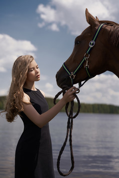 暗色调水边的女孩和马摄影图