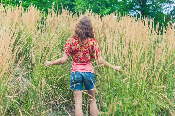 女人站在草地中摄影图