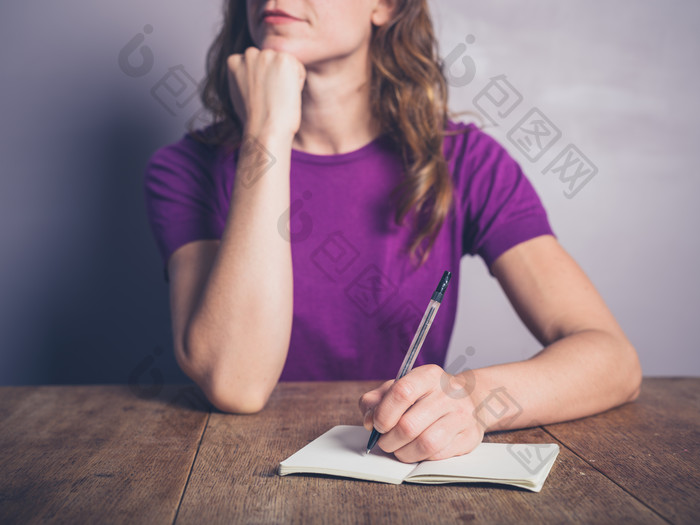紫色调记笔记的女子摄影图
