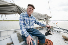 老年男人坐在船上钓鱼