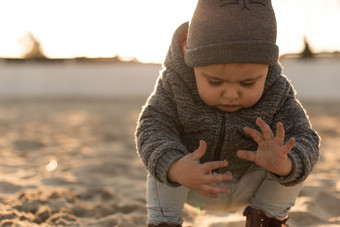 海边玩沙子的小男孩