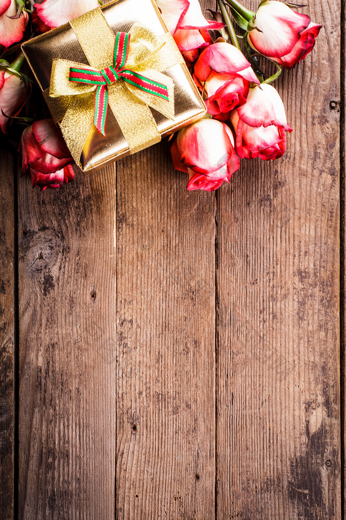 木桌上的玫瑰花和礼物
