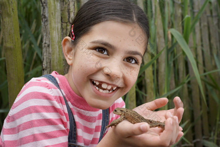 手捧着青蛙的小女孩