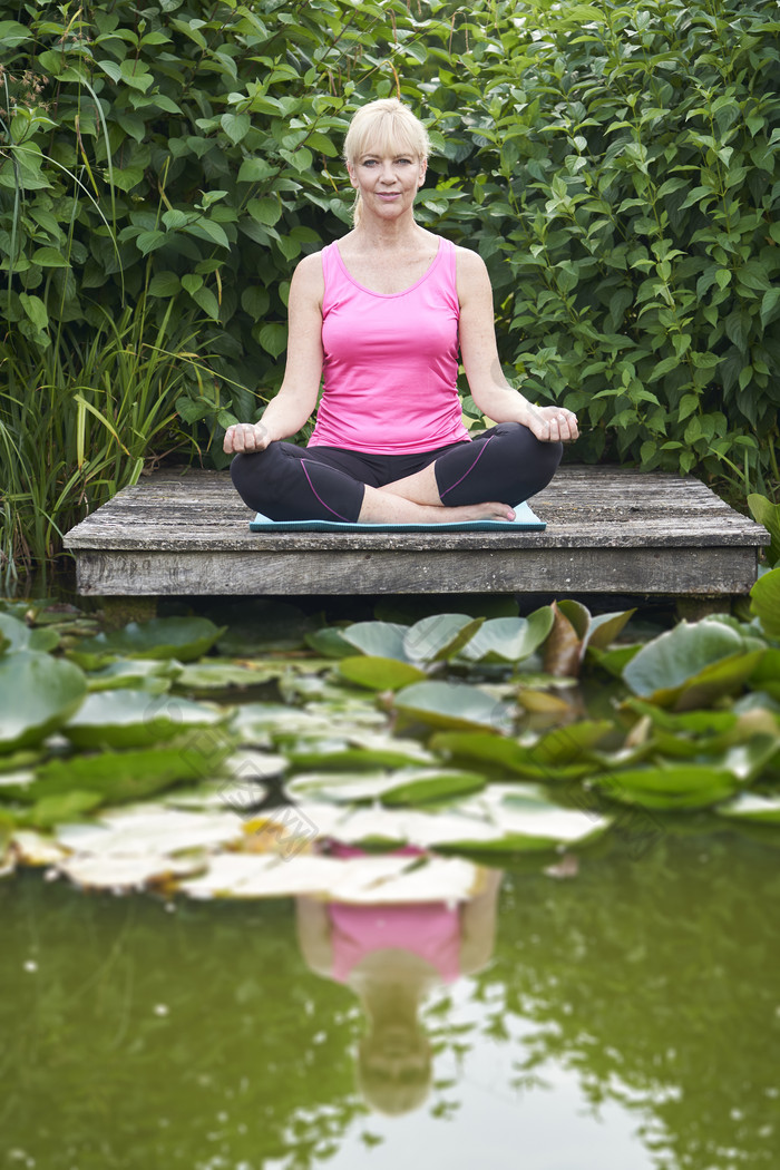 莲花池上练瑜伽的女人