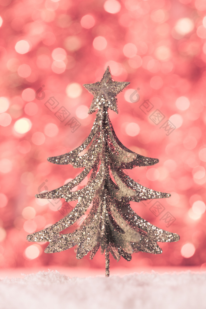 红色光斑背景前的圣诞树
