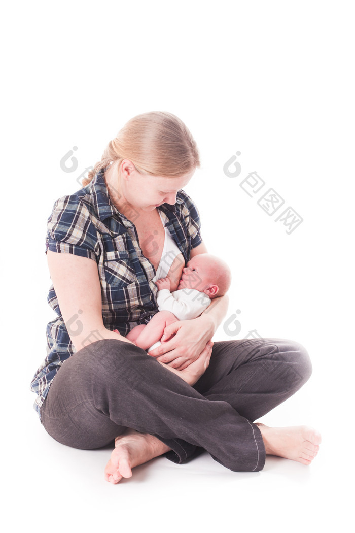 母亲坐在地上喂婴儿吃母乳